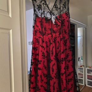 Red and black lace dress with roses on it.